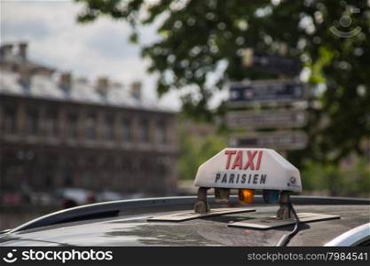 The Taxi sign on top of the roof of the cab in Paris