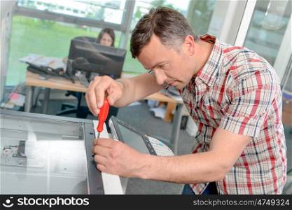 the technician fixing a printer
