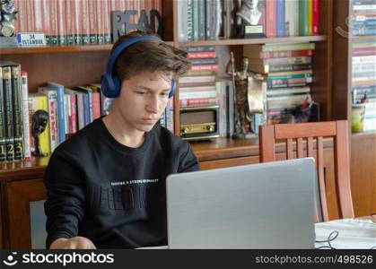 The teenage is listening to music at home