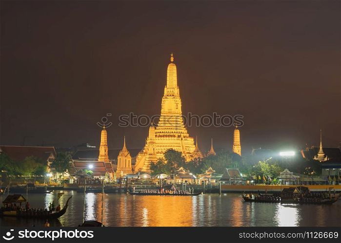 The Temple of Dawn, Wat Arun, with the royal barge procession for The Thai King on Chao Phraya River near Downtown of Bangkok City, Thailand. Thai architecture buildings background. Big ceremony.