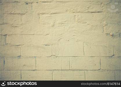 The texture of a brick wall painted with yellow paint