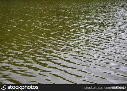 The texture of dark river water under the influence of wind, imprinted in perspective. Horizontal image