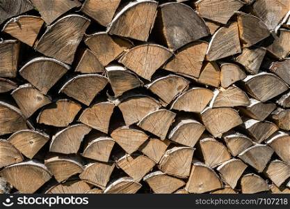 The texture of large birch firewood in bright sunlight.