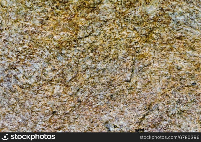 The texture of natural spotty brown, yellow and gray granite stone