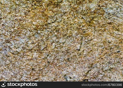 The texture of natural spotty brown, yellow and gray granite stone