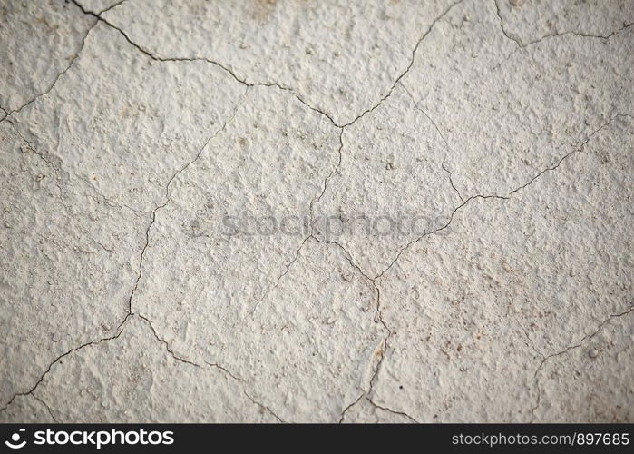 the texture of the earth in cracks. A textural, close-up image of sandy desert ground cracked by the heat and lack of water.
