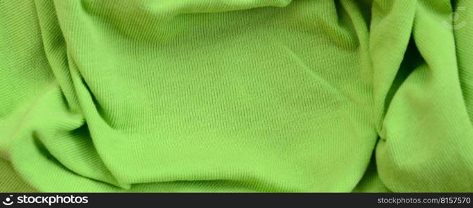 The texture of the fabric is bright green. Material for making shirts and blouses