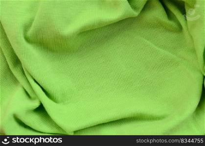 The texture of the fabric is bright green. Material for making shirts and blouses