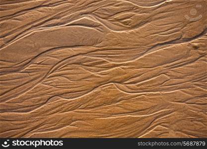 The texture of wet sea sand with patterns of water