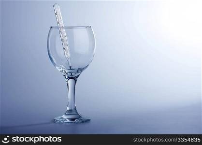 The thermometer in a glass on a blue background