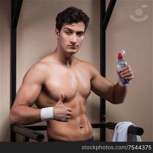 The thirsty man drinking water in sports gym. Thirsty man drinking water in sports gym