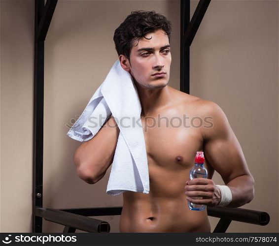 The thirsty man drinking water in sports gym. Thirsty man drinking water in sports gym