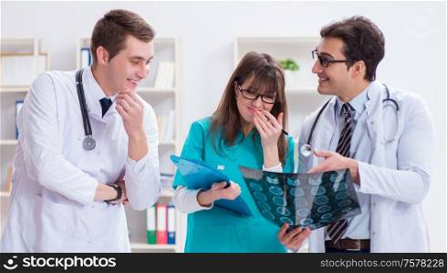 The three doctors discussing scan results of x-ray image. Three doctors discussing scan results of x-ray image