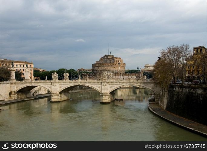 The Tiber River, Rome, Italia, swollen with flood waters, on a dull, cloudy day, wth the Castel Sant&rsquo; Angelo in the background