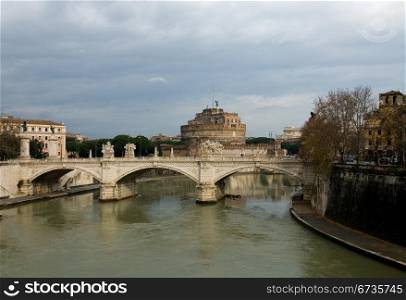 The Tiber River, Rome, Italia, swollen with flood waters, on a dull, cloudy day, wth the Castel Sant&rsquo; Angelo in the background