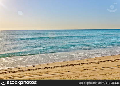 The tide rolls in at a golden sandy beach.