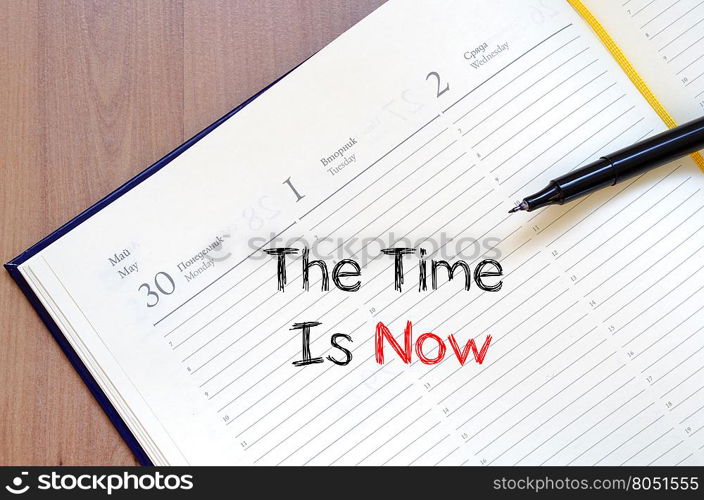 The time is now text concept write on notebook