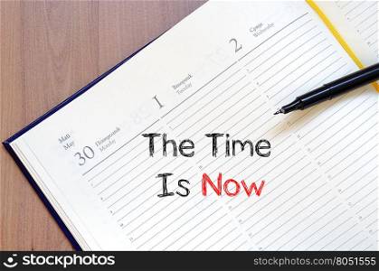 The time is now text concept write on notebook