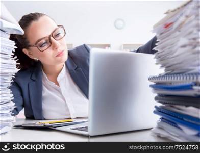 The tired businesswoman with paperwork workload. Tired businesswoman with paperwork workload
