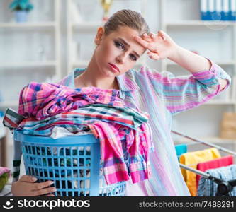 The tired depressed housewife doing laundry. Tired depressed housewife doing laundry