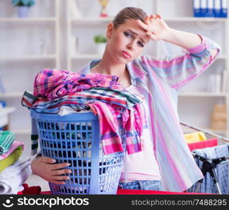 The tired depressed housewife doing laundry. Tired depressed housewife doing laundry
