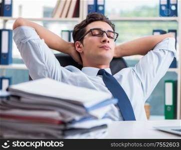 The tired exhausted businessman sitting in the office. Tired exhausted businessman sitting in the office
