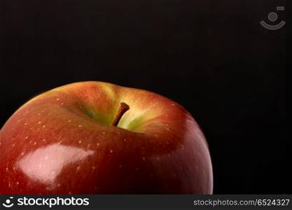 The top part of a juicy apple in a darkness. The juicy apple in a darkness
