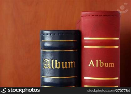 The top part of picture albums of dark blue and red color on a brown background