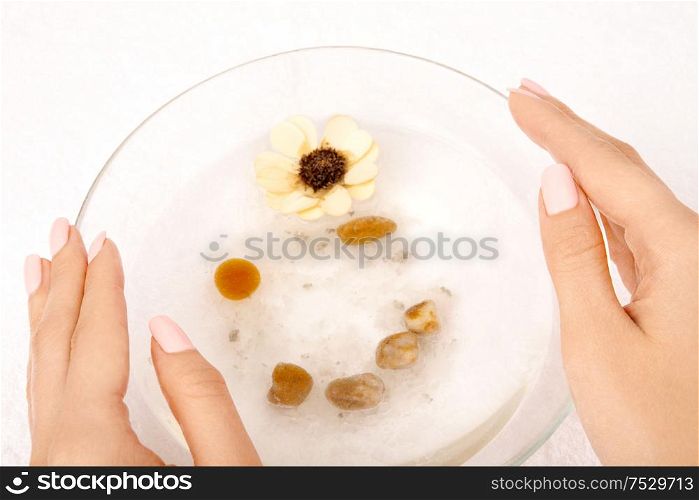 The top view - hands hold a bath with a flower and salt