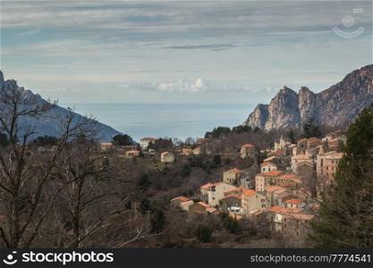 The town of Evisa in Corsica with mountains and the Mediterranean sea behind
