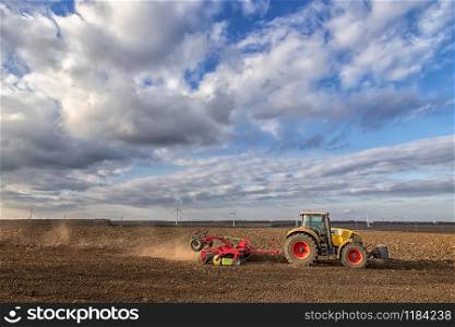 The tractor prepares the ground for sowing and cultivation. Agriculture and agronomy concept.