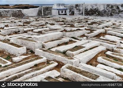 The traditional Jewish cemetery of Essaouria, Morocco is located outside the city walls next to the ocean and is filled with low tombs painted white.
