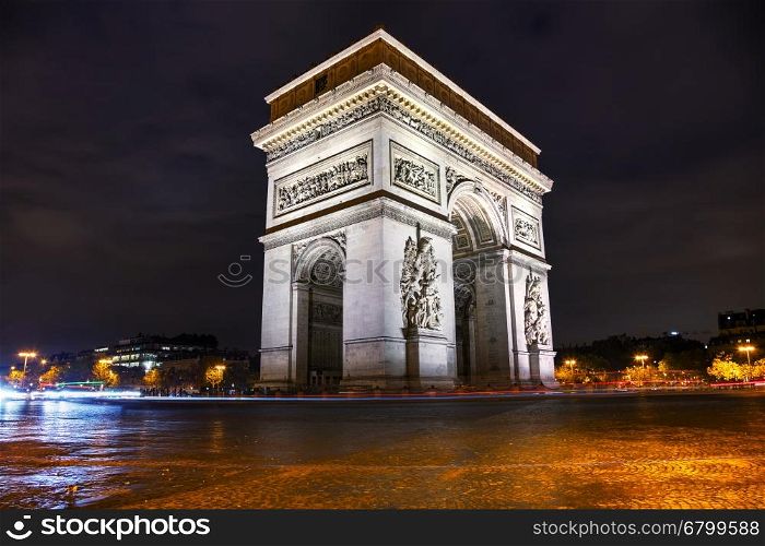 The Triumphal Arch (Arc de Triomphe) in Paris, France at night