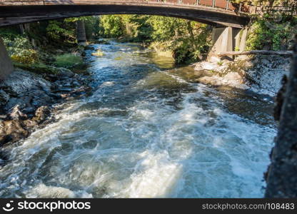 The Tumwater Rvier rushes beneath a walking bridge.