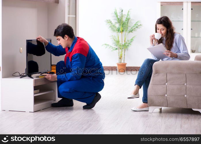 The tv repairman technician repairing tv at home. Tv repairman technician repairing tv at home