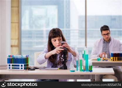 The two chemists working in lab experimenting. Two chemists working in lab experimenting