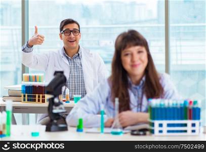 The two chemists working in lab experimenting. Two chemists working in lab experimenting