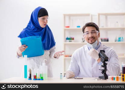 The two chemists working in the lab. Two chemists working in the lab