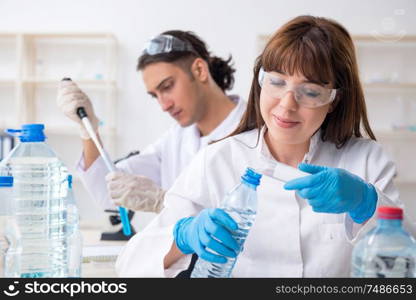 The two chemists working in the lab. Two chemists working in the lab