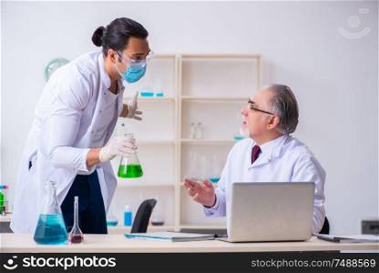 The two chemists working in the lab . Two chemists working in the lab