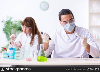 The two chemists working in the lab. Two chemists working in the lab