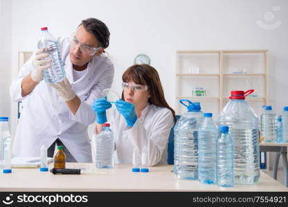 The two chemists working in the lab. Two chemists working in the lab