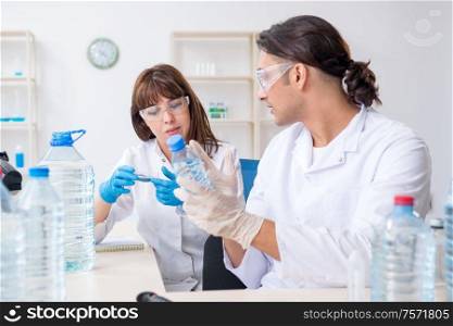 The two chemists working in the lab. Two chemists working in the lab