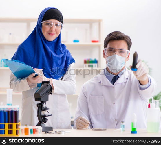 The two chemists working in the lab. Two chemists working in the lab