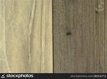 The two connected wooden panels,light and dark gray with visible scratches and grain.Interesting background.Close,horizontal view.