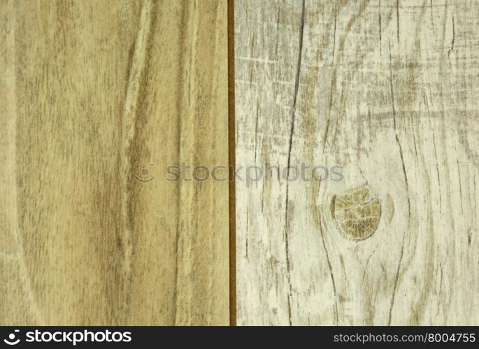 The two connected wooden panels,light and darker with visible scratches and grain.Close,horizontal view.