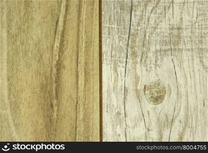 The two connected wooden panels,light and darker with visible scratches and grain.Close,horizontal view.