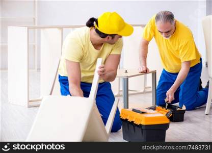 The two contractors carpenters working indoors . Two contractors carpenters working indoors