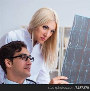 The two doctors examining x-ray images of patient for diagnosis. Two doctors examining x-ray images of patient for diagnosis