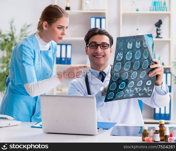 The two doctors examining x-ray images of patient for diagnosis. Two doctors examining x-ray images of patient for diagnosis